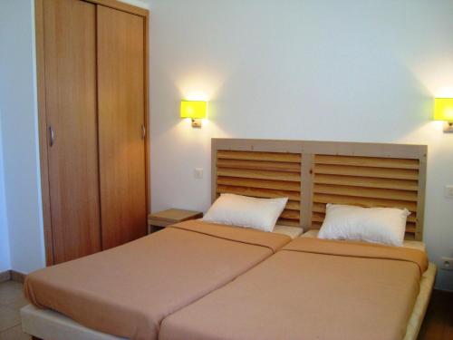 een slaapkamer met 2 bedden en 2 verlichting aan de muur bij Résidence Odalys San Martinu in Sainte-Lucie de Porto-Vecchio