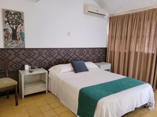 a hotel room with a bed and a chair at Hotel Gimaura in Ríohacha