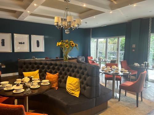 a living room with a couch and tables and chairs at The Fig Tree Hotel in Shanklin