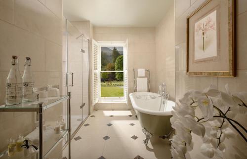 baño con bañera, lavabo y ventana en Inverlochy Castle Hotel, en Fort William