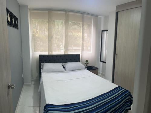 1 dormitorio con 1 cama grande frente a una ventana en Sabaneta Central Nómadas digitales Wi-Fi 201 en Sabaneta