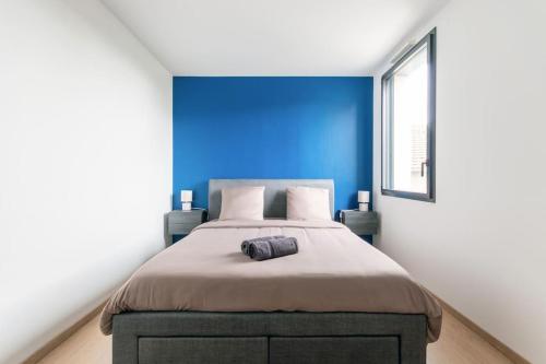 um quarto com uma cama grande e uma parede azul em Casa Mia em Fleury