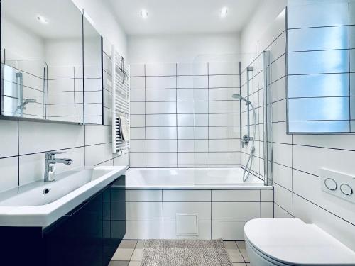 Baño blanco con lavabo y aseo en Business Apartment ZIMMERzuVERMIETEN in Solothurn, en Solothurn