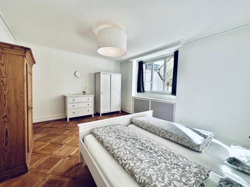 a bedroom with a bed and a dresser and a window at Business Apartment ZIMMERzuVERMIETEN in Solothurn in Solothurn