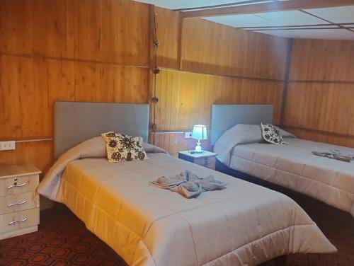 Habitación con 2 camas y toallas. en the wooden house choquequirao, en Cachora