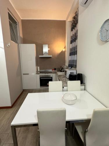 - une cuisine avec une table et des chaises blanches dans l'établissement Appartamento Colomba, à Plaisance