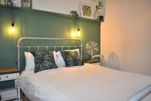 a bedroom with a bed with a green wall at Goodwood Events House with Garden & Parking - Chichester Holiday Properties in Chichester