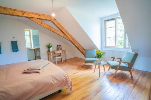 a bedroom with a bed and a table and chairs at La Pépite in Margut