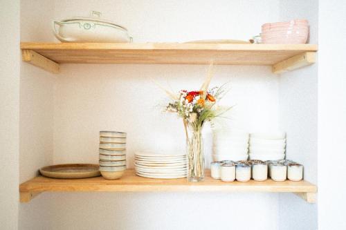 a vase of flowers sitting on a shelf with plates at La Pépite in Margut