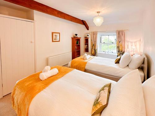 a bedroom with three beds and a window at A D Barn in Fremington