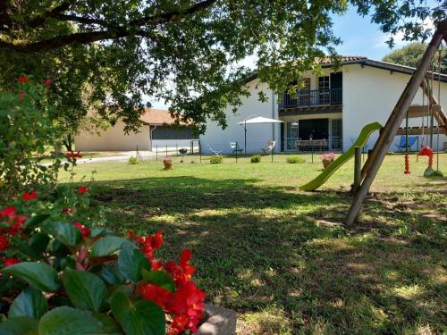 a yard with a playground and a building at L'etable in Orx