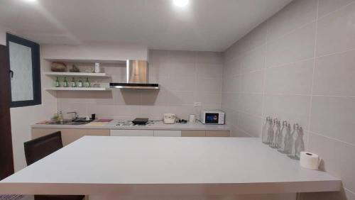 a white kitchen with a table and a counter top at Viva City Magamall Jazz 1 53 in Kuching