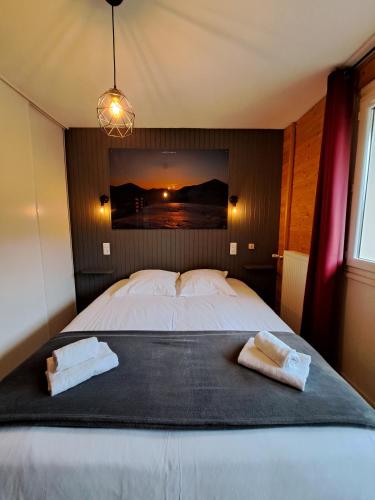 a bedroom with a bed with two towels on it at Hôtel Les Mouflons in Le Mont-Dore