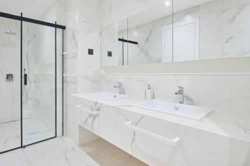 a white bathroom with two sinks and a shower at Villa Mirabel in Mimice