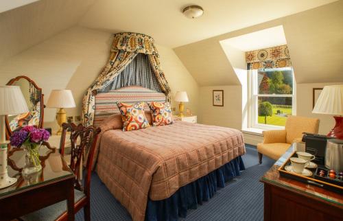 a bedroom with a bed with a canopy at Inverlochy Castle Hotel in Fort William
