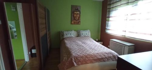 - une chambre dotée d'un lit avec une photo sur le mur dans l'établissement Cirilla Home, à Szombathely