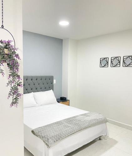 una camera bianca con un letto e una parete bianca di Sabaneta Central Nómadas digitales Wi-Fi 202 a Sabaneta