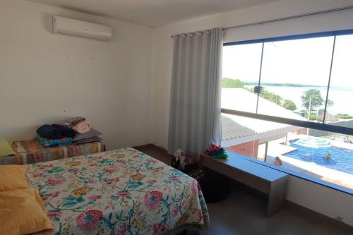 um quarto com uma cama e vista para uma piscina em Brisas do Paranapanema em Santa Inês