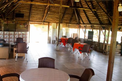 a dining room with tables and chairs in a restaurant at Buvuma Island Beach Hotel in Jinja