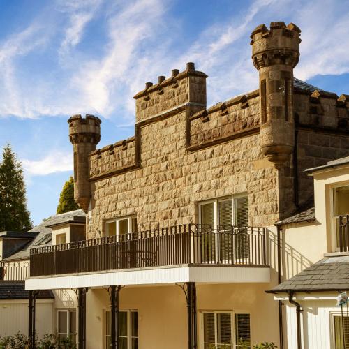 an old stone building with two chimneys on top at Inverlochy Castle Hotel in Fort William