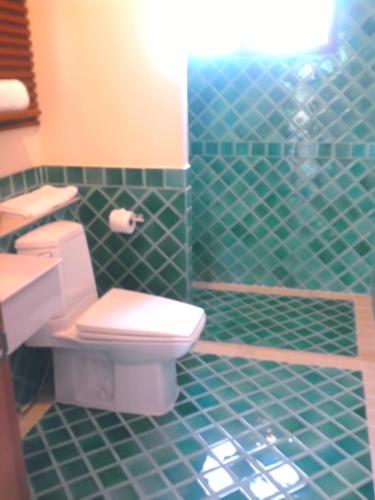 a green tiled bathroom with a toilet and a sink at Bhumlapa Garden Resort in Bophut