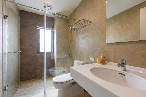 a bathroom with a toilet and a sink and a shower at Rainbow Field House in Jiji