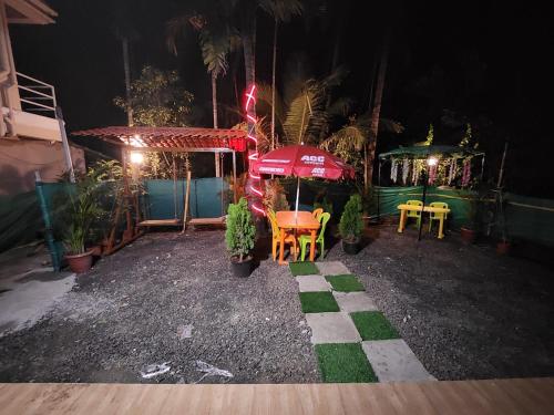 a patio with a table and chairs and an umbrella at Bhumi Holiday Home in Alibaug