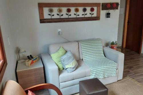 a living room with a white couch with pillows at Morada da Serra Alta in São Francisco de Paula