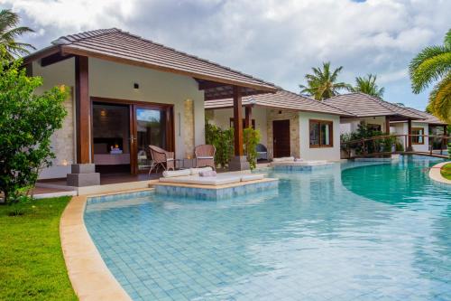 a swimming pool in front of a villa at AWARA POUSADA BOUTIQUE in São Miguel do Gostoso