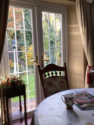 a table and a chair in front of a window at Tullyard House in Tullaghoge