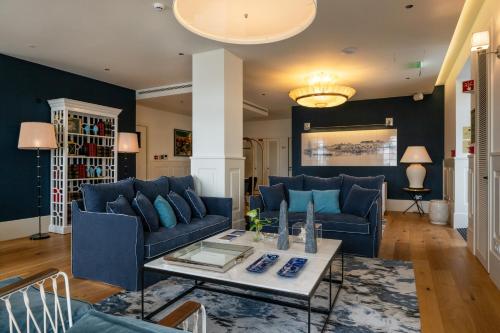 a living room with blue couches and a table at Dona Maria Hotel in Figueira da Foz