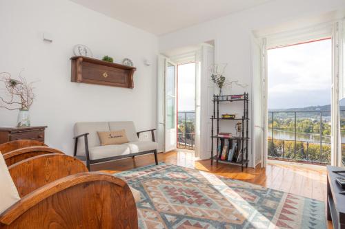 Una sala de estar con un sofá y un balcón. en Casas da Couraça, en Coímbra