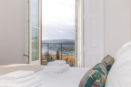 a room with a bed with a view of a window at Casas da Couraça in Coimbra