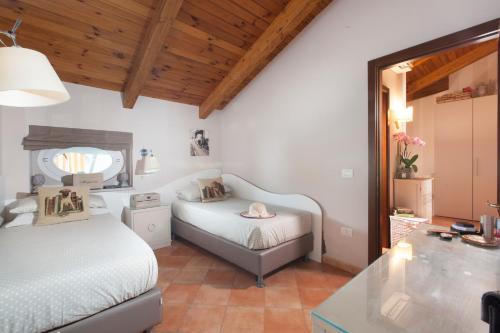 una camera da letto con due letti, un tavolo e uno specchio di AMORE RENTALS - Appartamento Terrazza Tasso a Sorrento