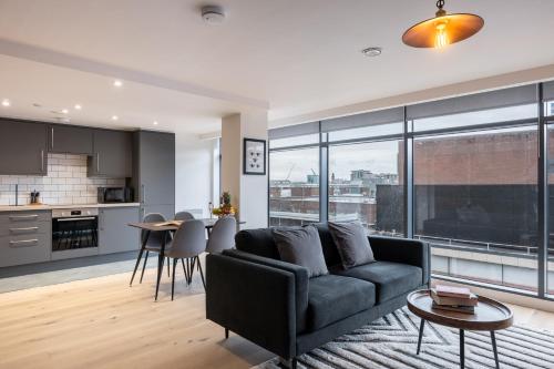 a living room with a couch and a kitchen at Kula Manchester in Manchester
