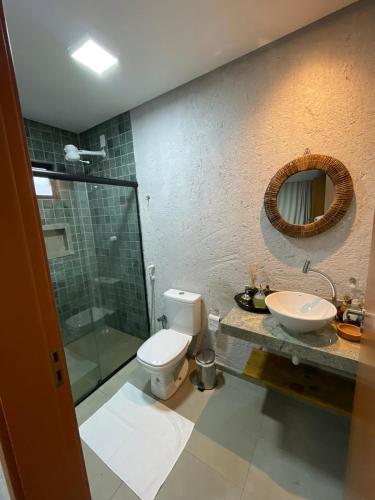 a bathroom with a toilet and a sink and a mirror at CASA EM SÃO MIGUEL DOS MILAGRES in São Miguel dos Milagres