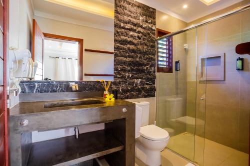 a bathroom with a sink and a toilet and a shower at AWARA POUSADA BOUTIQUE in São Miguel do Gostoso