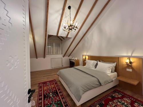 a bedroom with a bed and a ceiling with a chandelier at Chestnut Hill in Kolgecaj