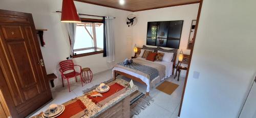 um quarto com uma cama e uma sala de estar em Chalés Metanóia em São Pedro da Serra