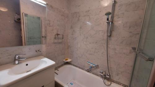 een badkamer met een bad, een wastafel en een douche bij Residentie Koksijde promenade in Koksijde