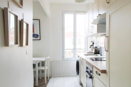 Le Pré-Saint-GervaisにあるWell Equipped 40m Apartment Near Parisの白いキッチン(シンク付)、窓
