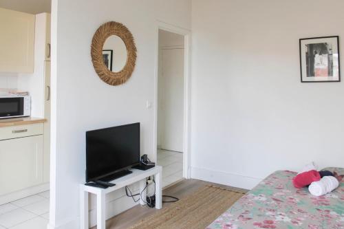 uma sala de estar com uma televisão e uma cama em Well Equipped 40m Apartment Near Paris em Le Pré-Saint-Gervais