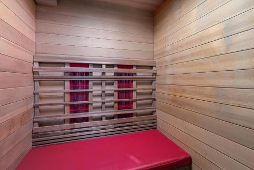 uma sauna com um banco vermelho numa parede de madeira em J and R flanders fields holiday homes em Diksmuide