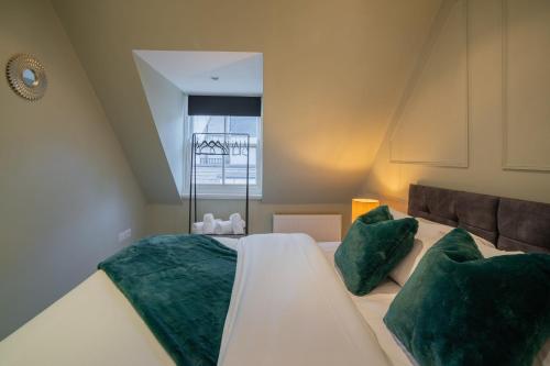 a bedroom with a large bed with green pillows at Four Bed House At Primal Estates Short Lets in Brighton in Brighton & Hove
