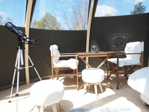 een camera op een statief naast een tafel en stoelen bij Bulle nuage - Etat Nature in Magnières
