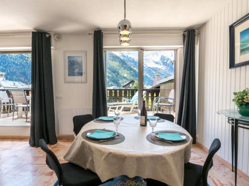 une salle à manger avec une table et une grande fenêtre dans l'établissement Grand appartement avec terrasse face au Mont-Blanc, parking et WiFi - FR-1-343-173, à Chamonix-Mont-Blanc