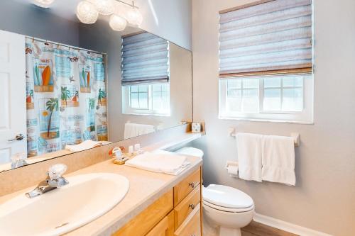 a bathroom with a sink and a toilet and a mirror at Madeira Beach Manor in St Pete Beach