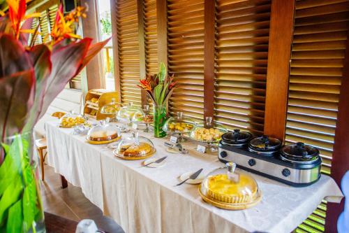 a table with plates of food on it at AWARA POUSADA BOUTIQUE in São Miguel do Gostoso