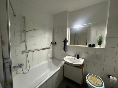 y baño con bañera, lavamanos y ducha. en Brix Apartment, en Naumburg
