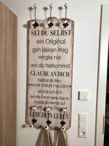 a sign hanging on a wall in a bathroom at Stylisches Maybach Appartement mit Terrasse für 5 Personen, 5 Betten, große Kochinsel, Homeoffice mit 250Mbit WLAN in Aidlingen